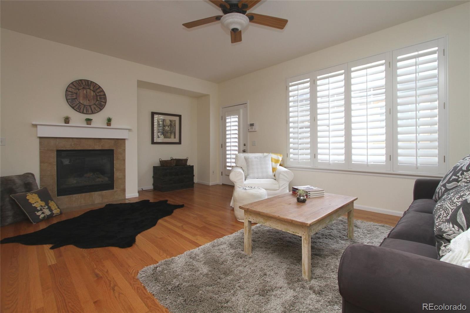 9489 Cedarhurst Lane, Unit B Highlands Ranch, CO 80129 - Photo 4 of 20 a living room with furniture a fireplace and a table