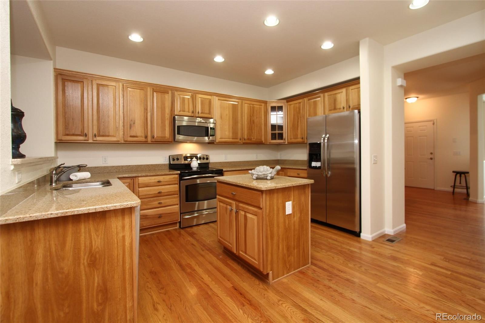 9489 Cedarhurst Lane, Unit B Highlands Ranch, CO 80129 - Photo 7 of 20 a kitchen with stainless steel appliances granite countertop a sink stove and refrigerator