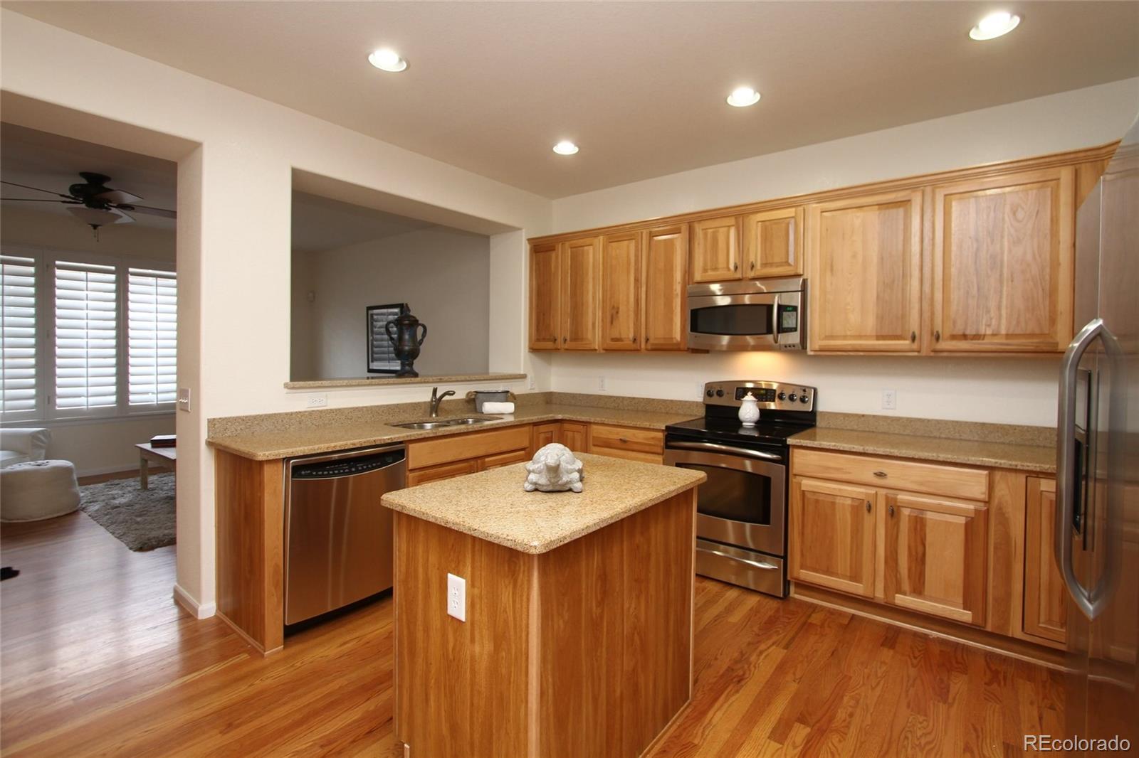 9489 Cedarhurst Lane, Unit B Highlands Ranch, CO 80129 - Photo 8 of 20 a kitchen with stainless steel appliances granite countertop wooden cabinets sink and stove