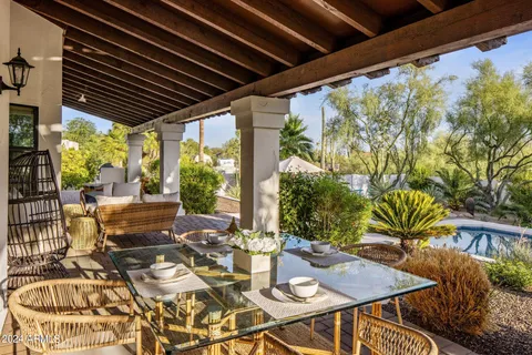 a view of a patio with table and chairs potted plants with floor to ceiling window