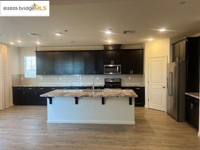 5464 Gallier Loop Antioch, CA 94531 - Photo 2 of 11 a large kitchen with stainless steel appliances wooden cabinets and wooden floor