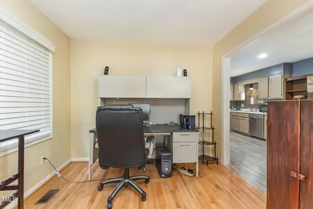 a view of a workspace with furniture and a window