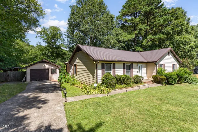 a front view of a house with yard and green space