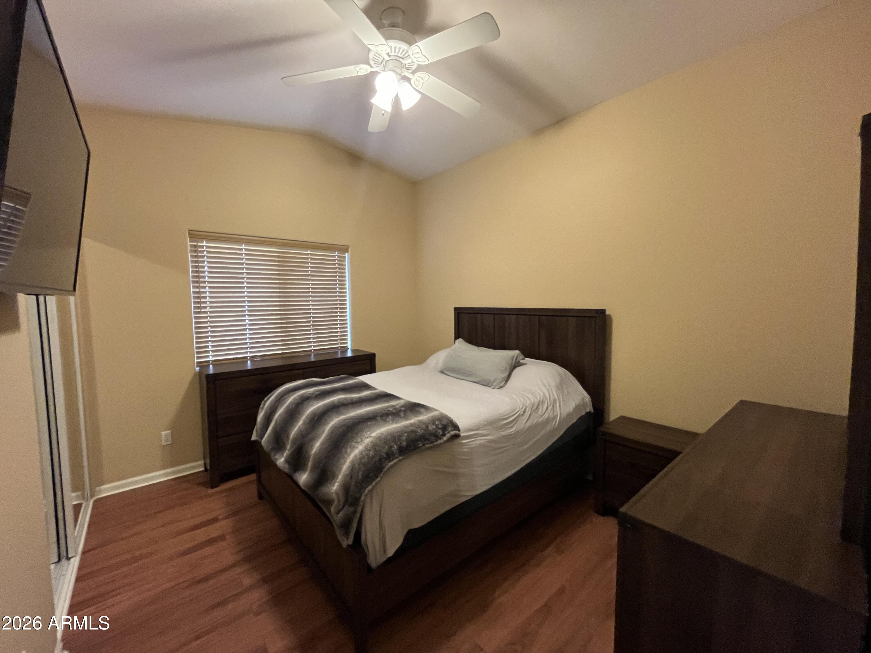 802 East Roberts Road Phoenix, AZ 85022 - Photo 17 of 33 a bedroom with a bed and wooden floor