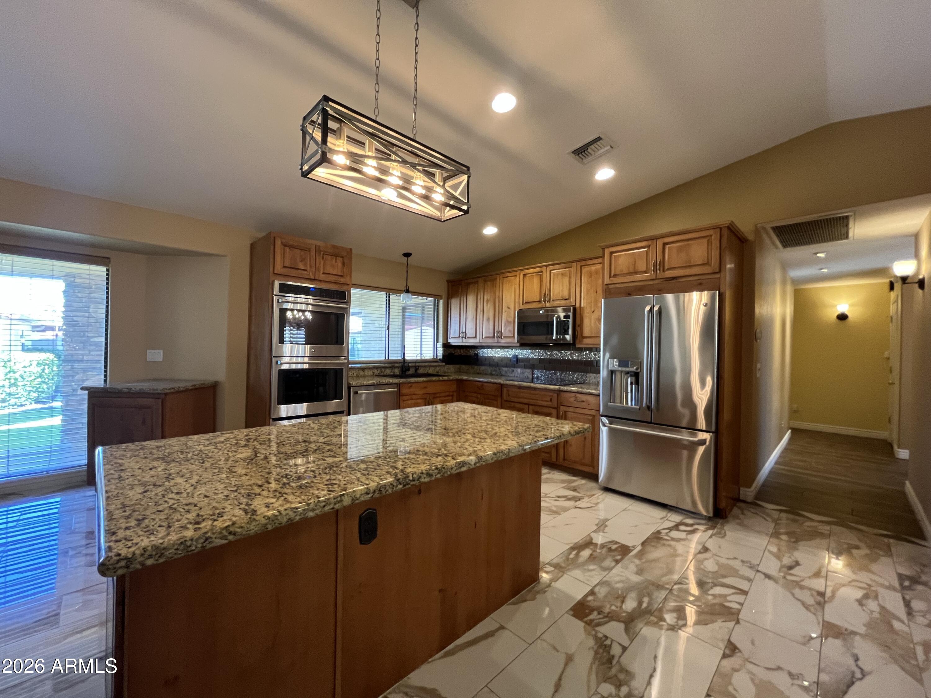 802 East Roberts Road Phoenix, AZ 85022 - Photo 8 of 33 a large kitchen with kitchen island granite countertop a large counter top and stainless steel appliances