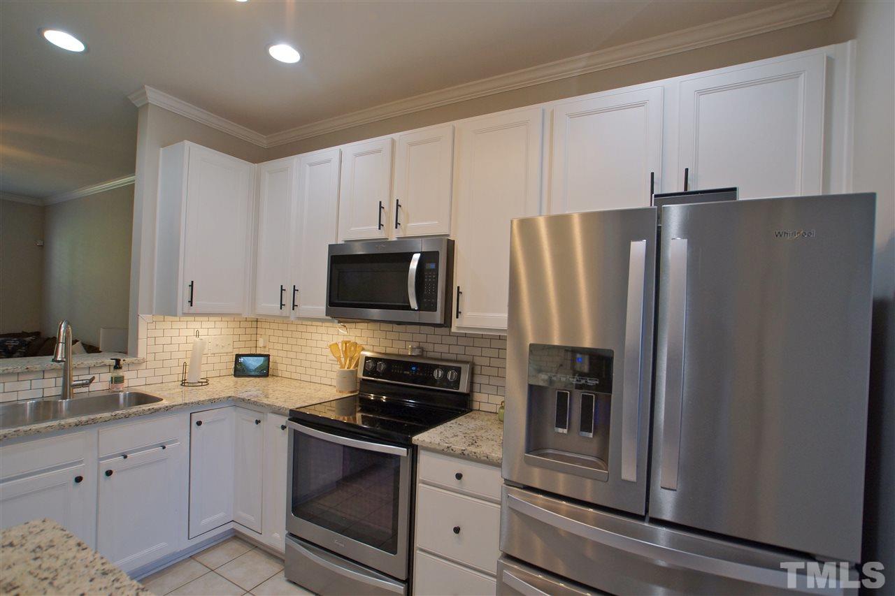 4807 Sir Duncan Way Raleigh, NC 27612 - Photo 12 of 29 a kitchen with granite countertop white cabinets and stainless steel appliances