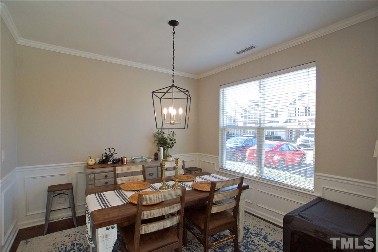 4807 Sir Duncan Way Raleigh, NC 27612 - Photo 16 of 29 a dining room with furniture a chandelier and wooden floor