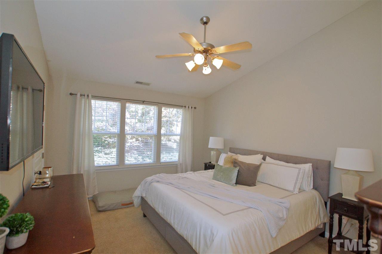 4807 Sir Duncan Way Raleigh, NC 27612 - Photo 21 of 29 a bedroom with a large bed and a chandelier