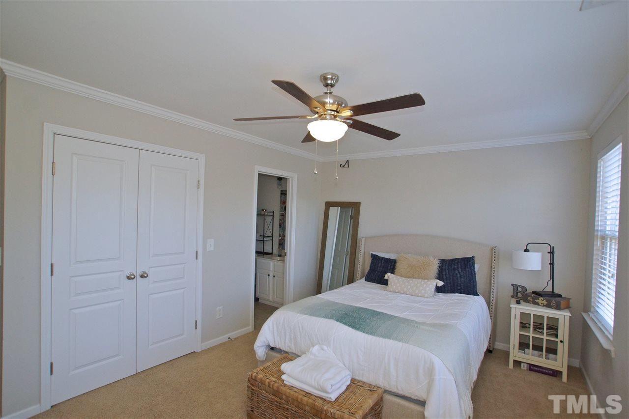4807 Sir Duncan Way Raleigh, NC 27612 - Photo 25 of 29 a bedroom with a bed and a chandelier