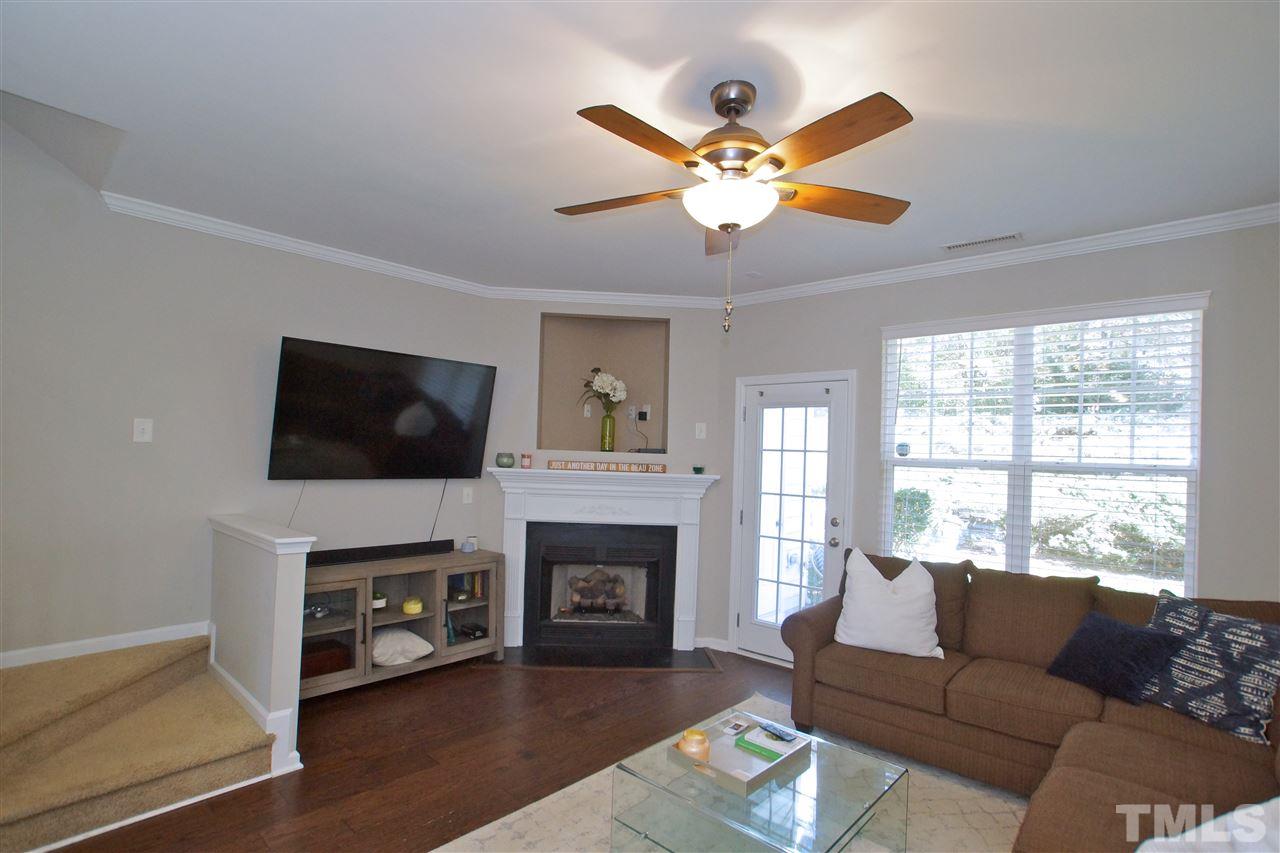 4807 Sir Duncan Way Raleigh, NC 27612 - Photo 6 of 29 a living room with furniture a fireplace and a flat screen tv