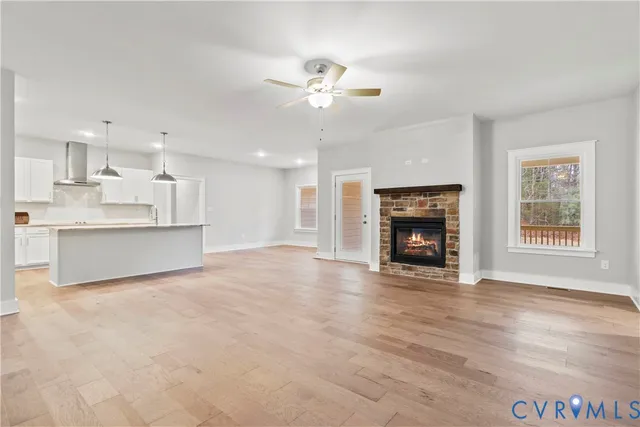 a view of an empty room with a fireplace and a window