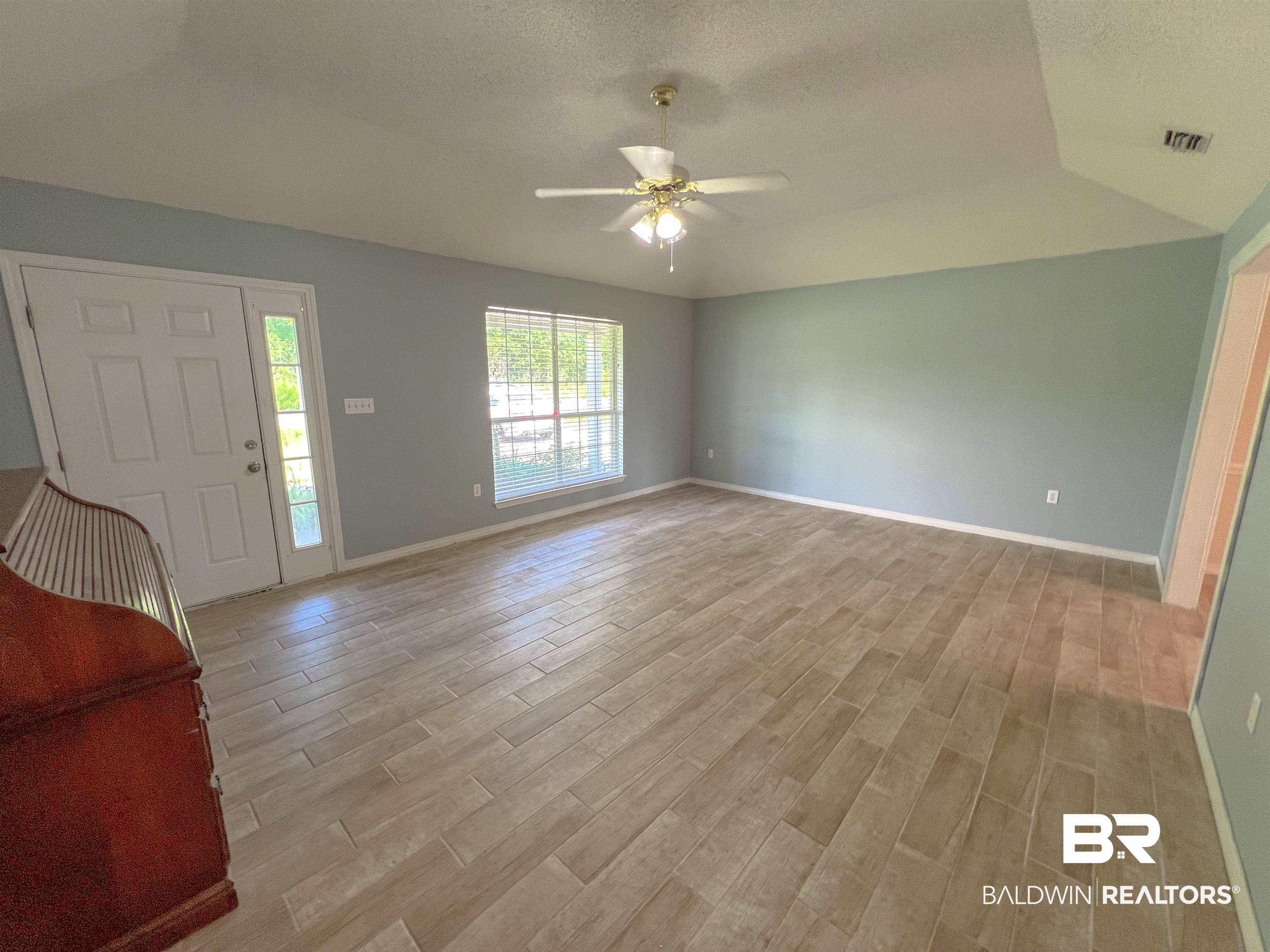 1200 South Juniper Street Foley, AL 36535 - Photo 2 of 23 Interior space featuring lofted ceiling, a textured ceiling, light hardwood / wood-style flooring, and ceiling fan