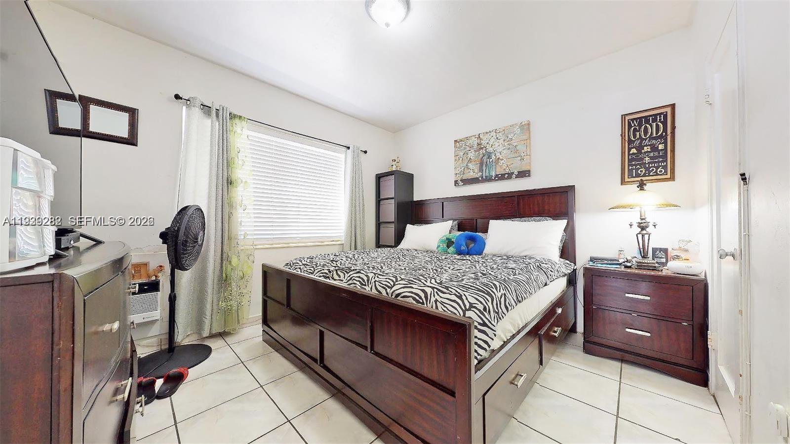 2499 Southwest 27th Street, Unit 1 Miami, FL 33133 - Photo 11 of 14 a bedroom with a bed and a chandelier