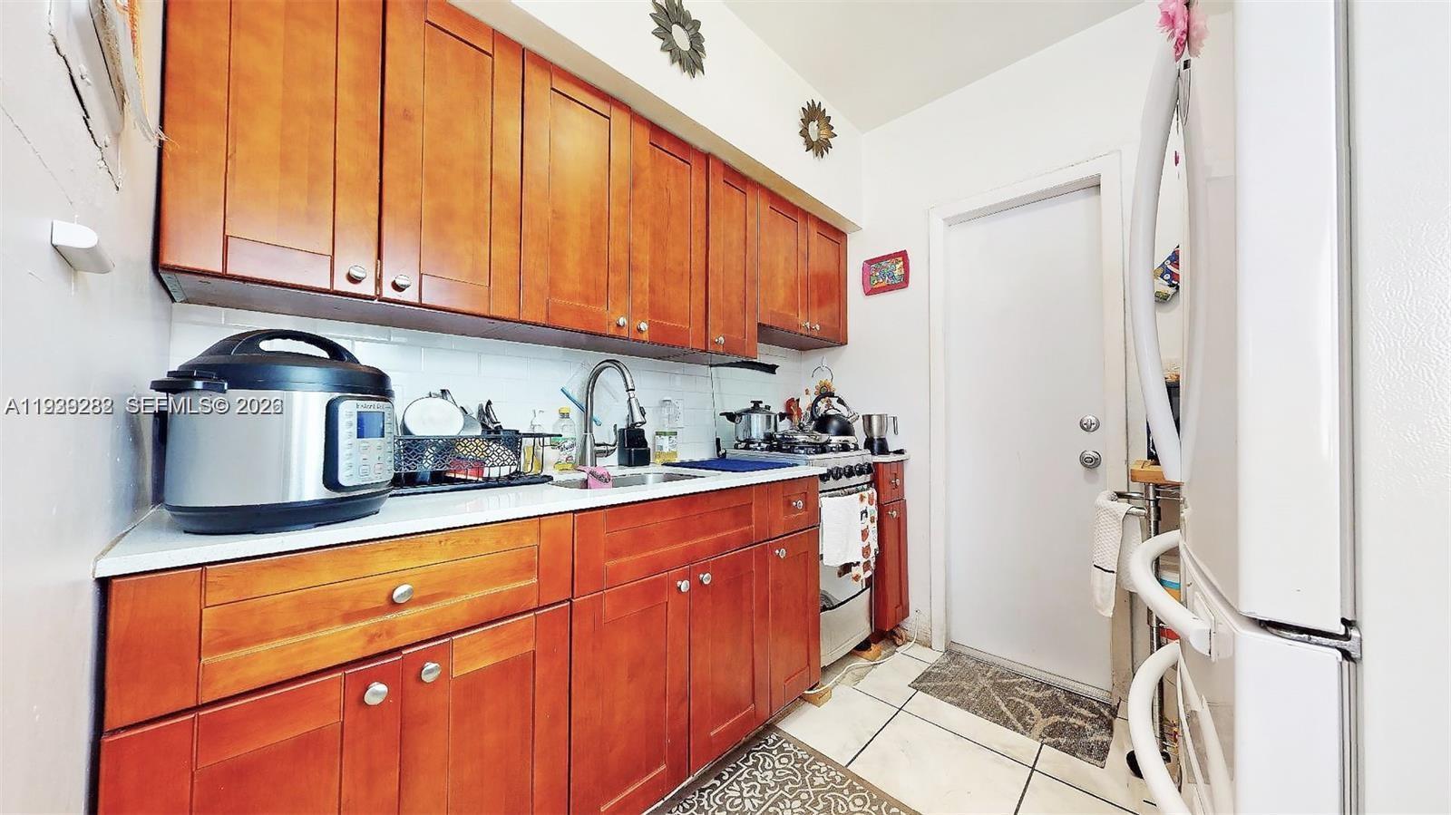 2499 Southwest 27th Street, Unit 1 Miami, FL 33133 - Photo 8 of 14 a kitchen with stainless steel appliances granite countertop a refrigerator and a stove top oven