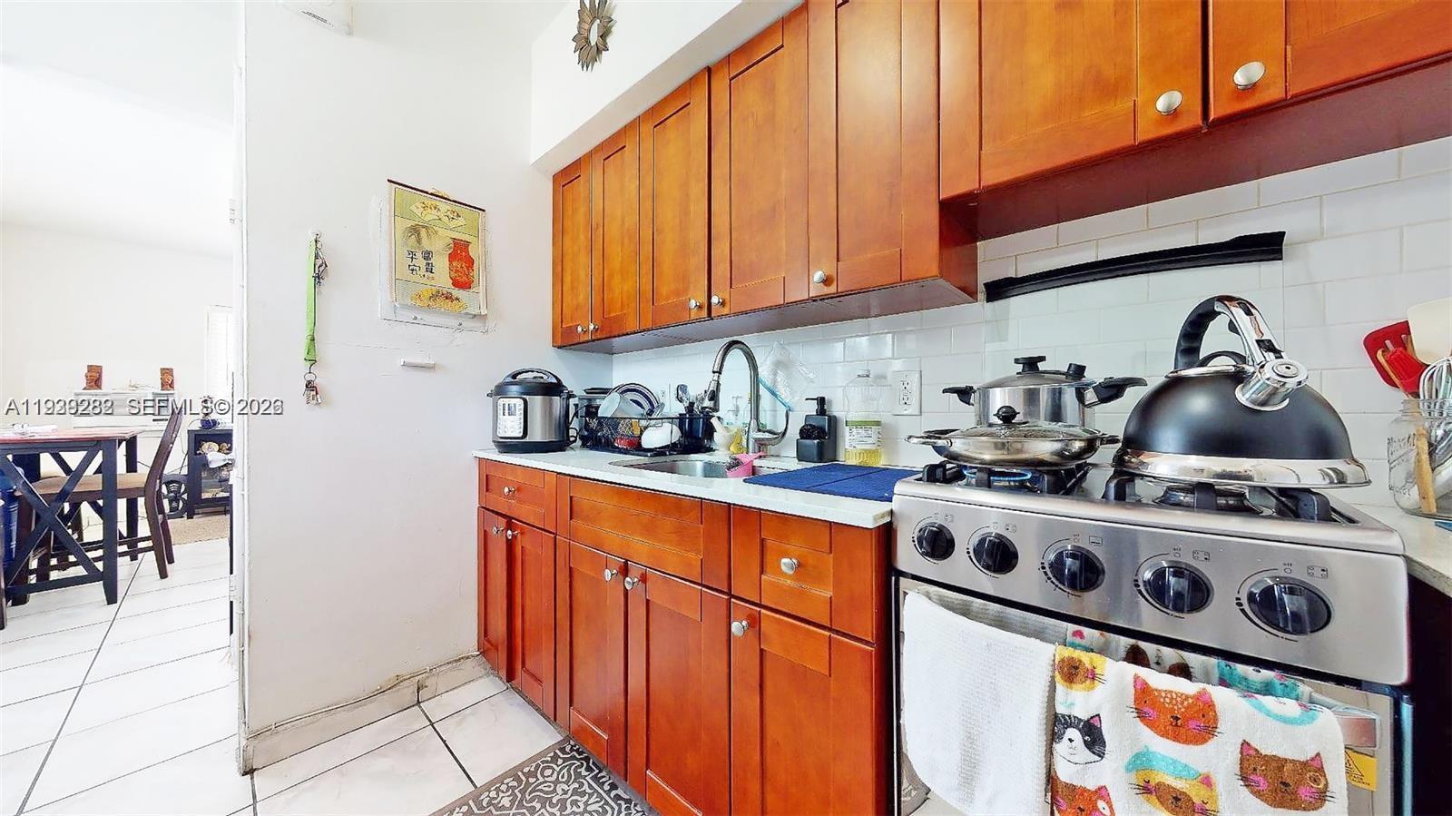 2499 Southwest 27th Street, Unit 1 Miami, FL 33133 - Photo 9 of 14 a kitchen with stainless steel appliances granite countertop a stove a sink and a microwave