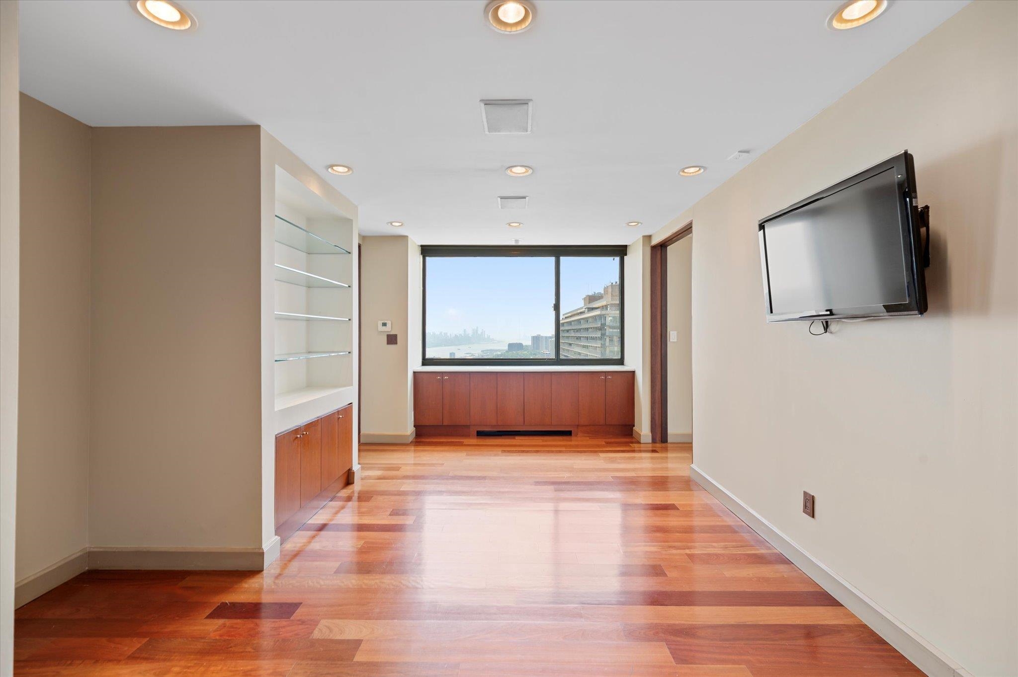 200 Old Palisade Road, Unit PH 4/5 Fort Lee, NJ 07024 - Photo 13 of 46 a view of an empty room with wooden floor and a window