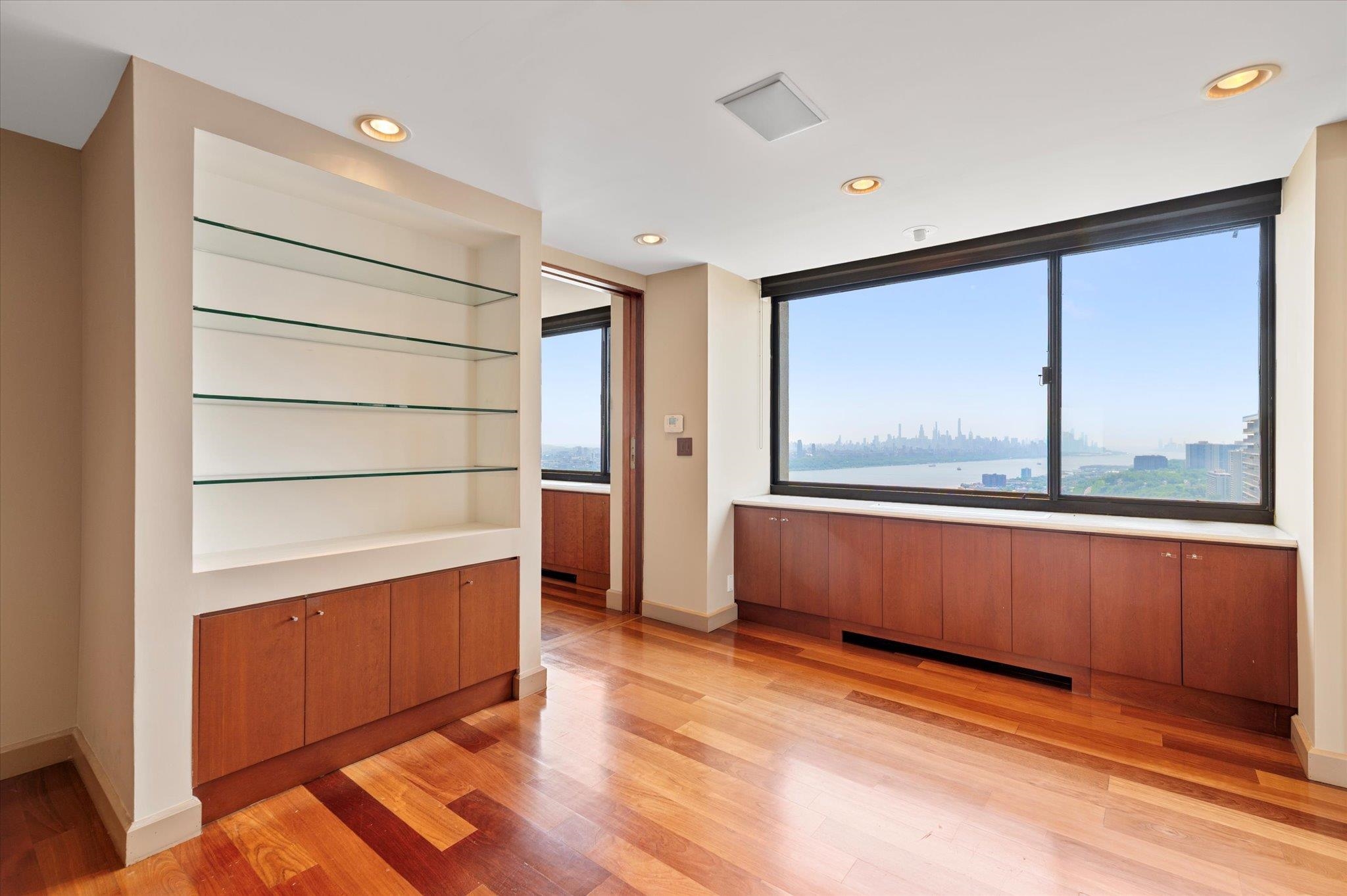 200 Old Palisade Road, Unit PH 4/5 Fort Lee, NJ 07024 - Photo 14 of 46 a view of an empty room with wooden floor and a window