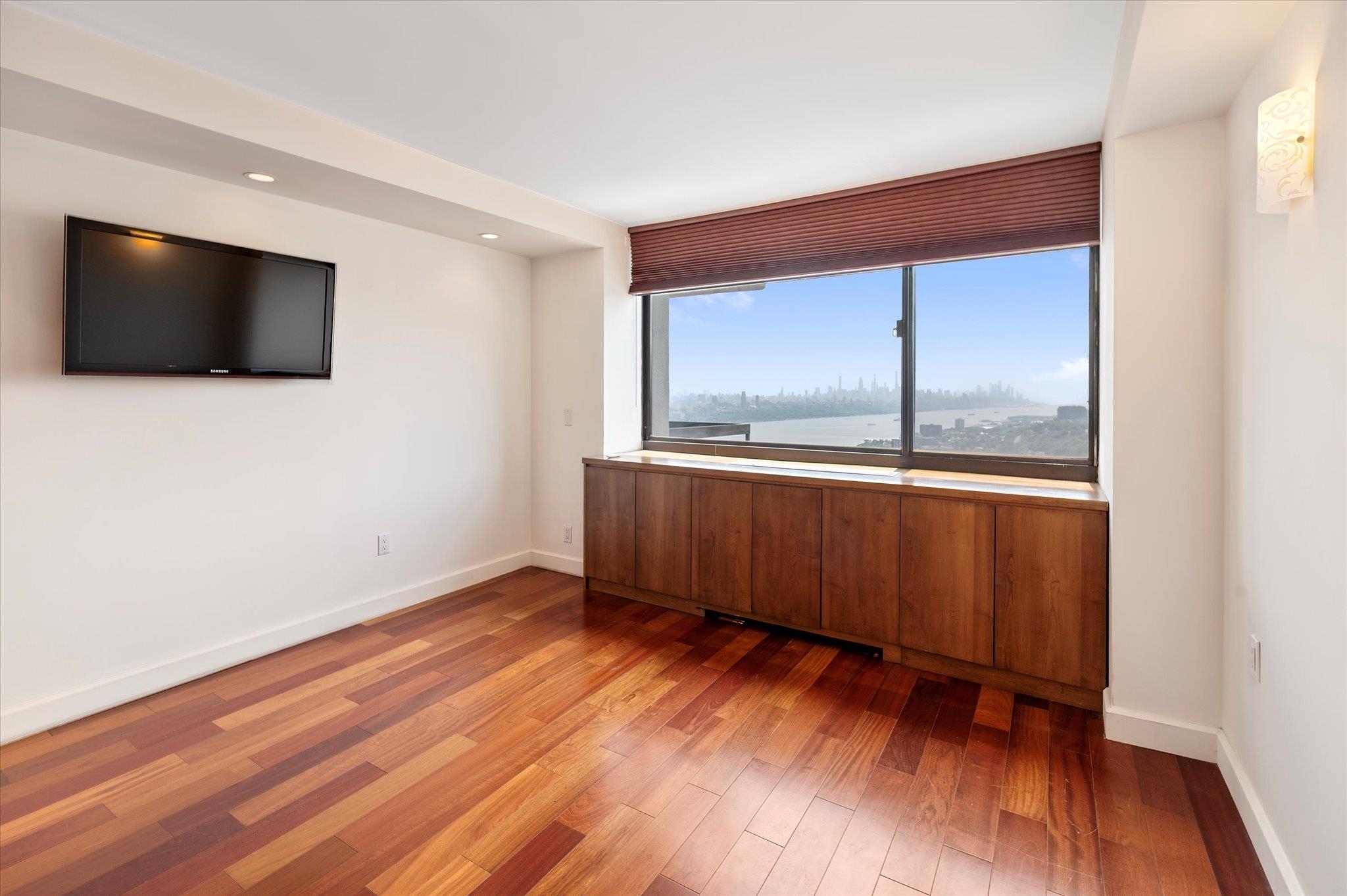 200 Old Palisade Road, Unit PH 4/5 Fort Lee, NJ 07024 - Photo 32 of 46 a view of an empty room with wooden floor and a window