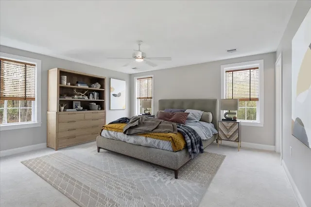 a spacious bedroom with a bed a dresser and a window