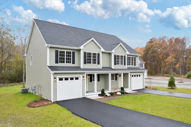 a front view of a house with a yard and lake view