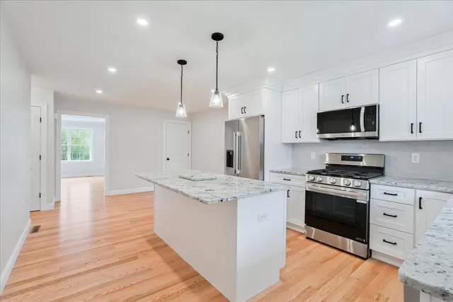 a kitchen with stainless steel appliances granite countertop a stove a sink and a refrigerator