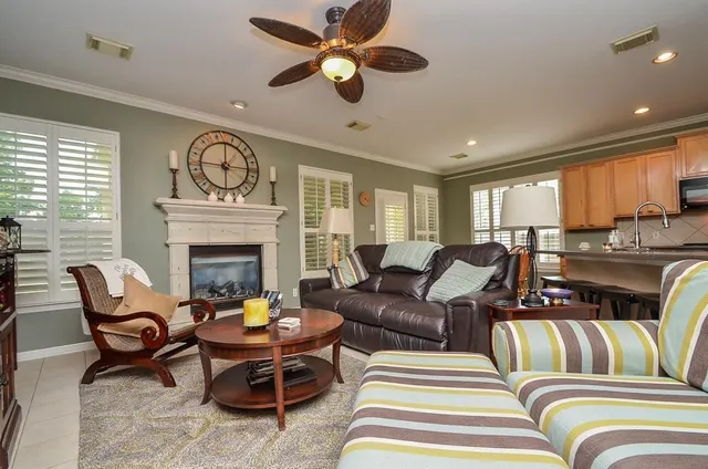 a living room with furniture a fireplace and a ceiling fan