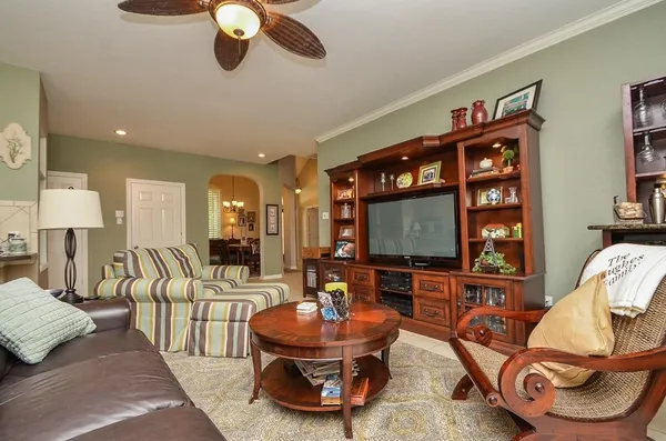a living room with furniture kitchen view and a large window