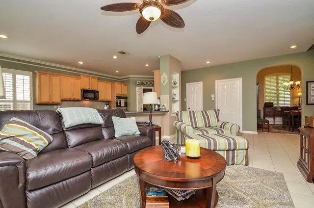 a living room with furniture kitchen view and a large window
