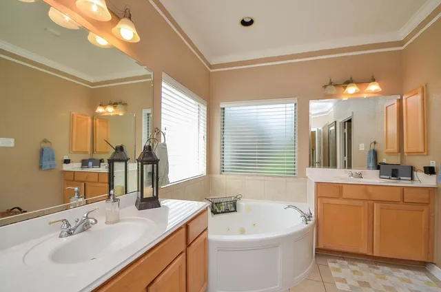 a bathroom with a sink a large mirror and a bathtub