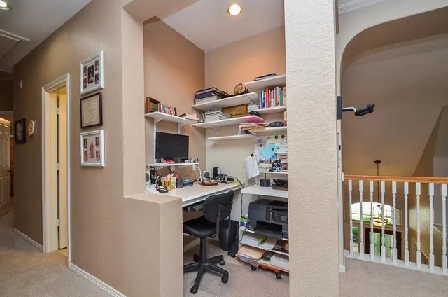 a view of a workspace with furniture and a window