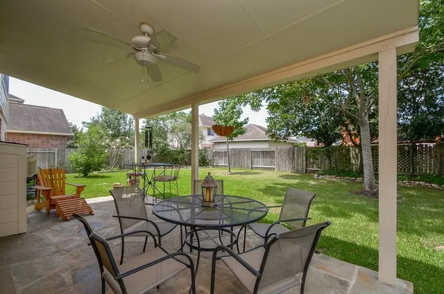 a view of patio with table and chairs under an umbrella