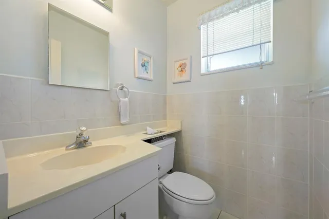 a bathroom with a sink toilet and a mirror