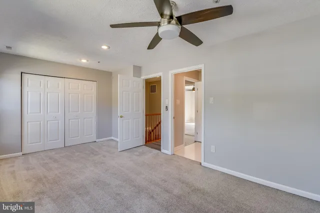 a view of an empty room and a ceiling fan
