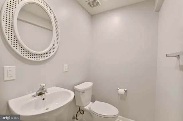 a bathroom with a sink a mirror and a toilet