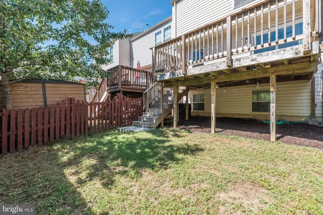 a view of a house with backyard and wooden fence