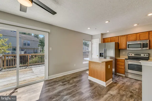 a kitchen with stainless steel appliances granite countertop a refrigerator and a stove top oven
