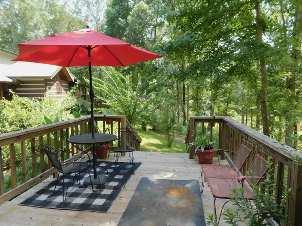 a view of a wooden deck with furniture and backyard