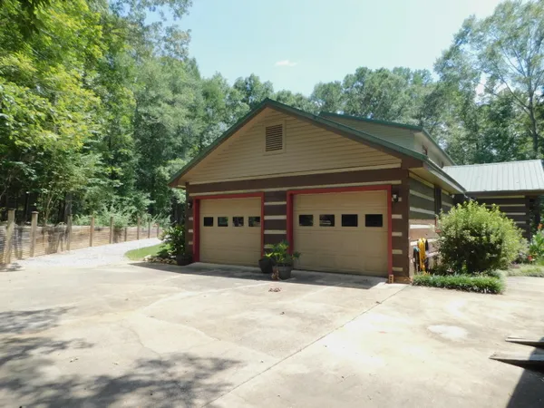 a front view of house with yard and trees in the background