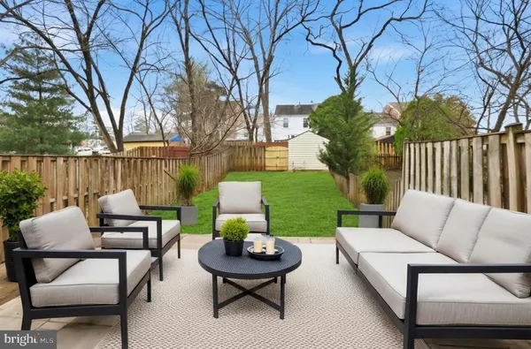 a view of a patio with couches table and chairs with wooden fence and floor