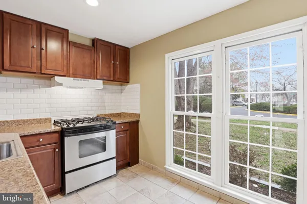 a kitchen with wooden cabinets and a stove top oven
