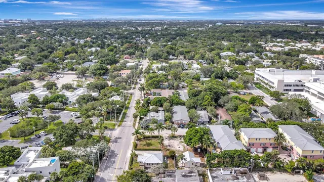 an aerial view of residential houses with outdoor space and trees