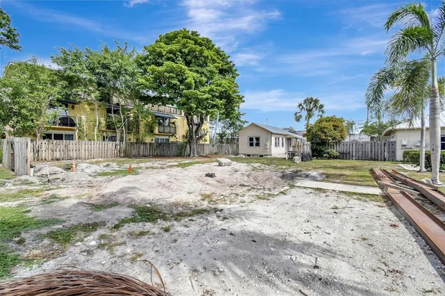 a view of house with yard and trees in the background
