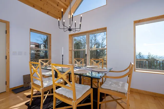 a view of a dining room with furniture large windows and wooden floor