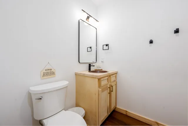 a bathroom with a toilet a sink and mirror