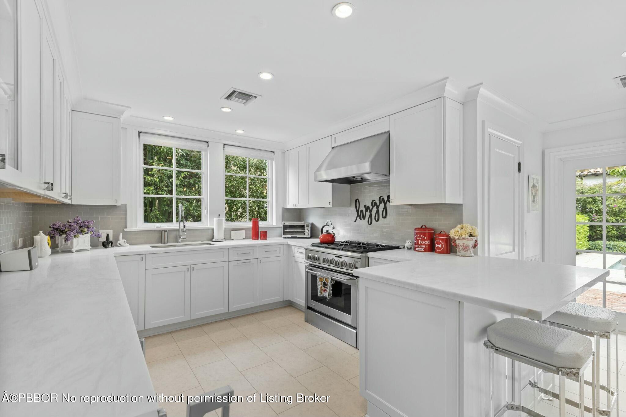 281 Cordova Road West Palm Beach, FL 33401 - Photo 14 of 25 a kitchen with a stove a sink dishwasher and white cabinets with wooden floor