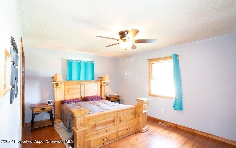 1407 County Road 237 Silt, CO 81652 - Photo 14 of 32 a bedroom with a bed and a chandelier