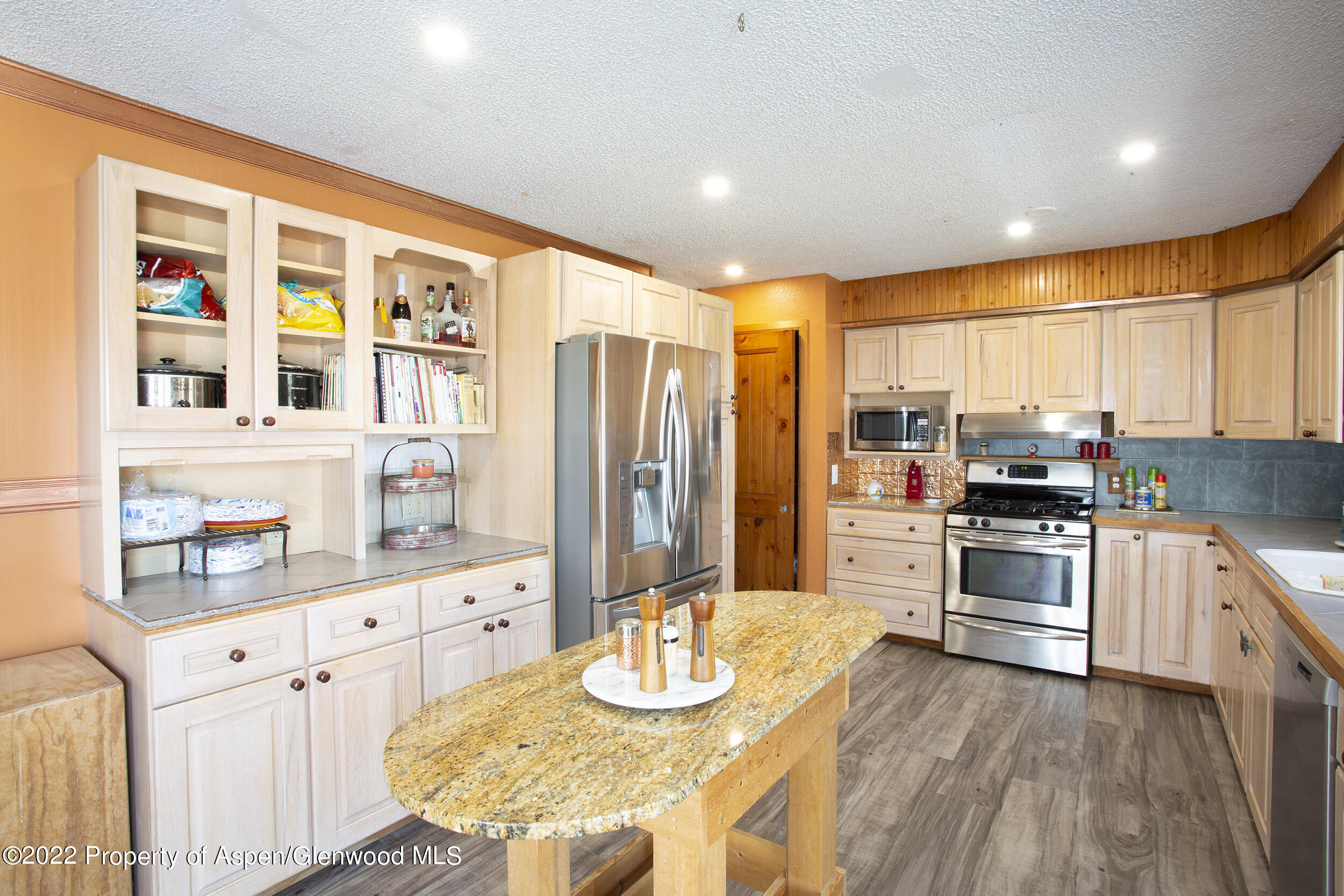 1407 County Road 237 Silt, CO 81652 - Photo 5 of 32 a kitchen with stainless steel appliances granite countertop a stove top oven a sink dishwasher a dining table and chairs with wooden floor