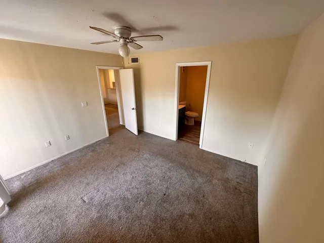 a view of a livingroom with a chandelier fan and a ceiling fan