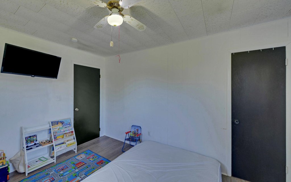 810 Grassy Creek Road Copperhill, TN 37317 - Photo 19 of 33 a bedroom with a bed and a chandelier