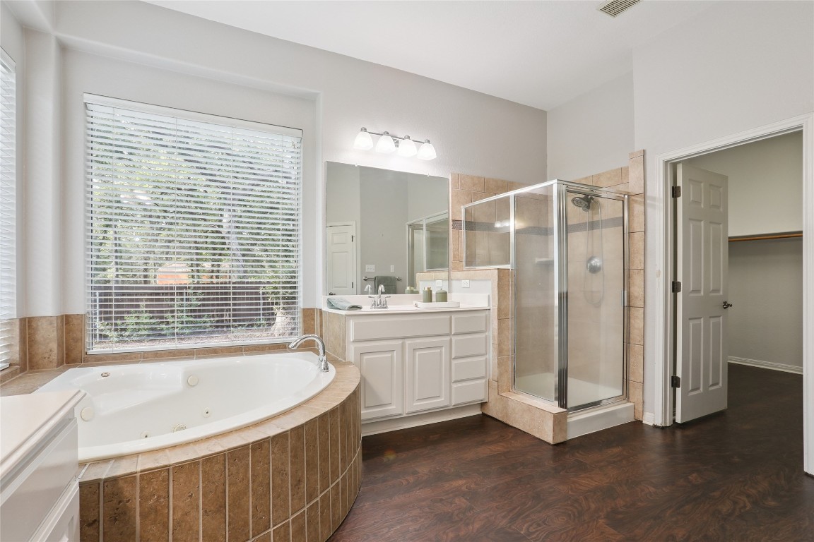 120 Juniper Trail Elgin, TX 78621 - Photo 14 of 32 Full bath featuring a stall shower, vanity, dark wood-style floors, and a whirlpool tub